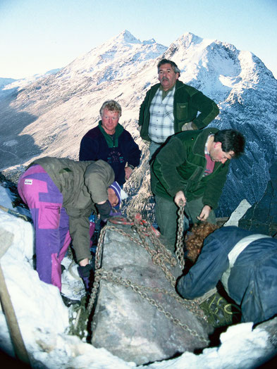 Manganbergwerk Starlera 15. Dezember 1994. Der 1500 kg schwere Eisen-Mangan-Erzblock wird zum Abtransport mit dem Hubschrauber vorbereitet. Bergbau in Innerferrera, Schams.